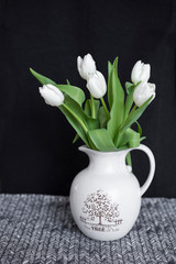 white tulips in a vase on dark background