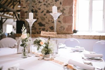 Hochzeitslocation gedeckter Tisch mit Blumen und Dekoration