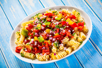 Pasta with vegetables on wooden background