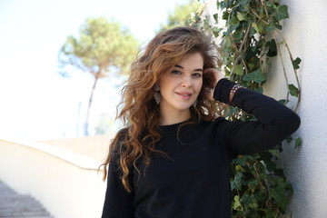  portrait of a young beautiful woman of model appearance in the park on a background of green trees
