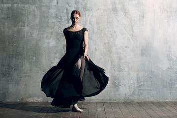 Ballerina female. Young beautiful woman ballet dancer, dressed in professional outfit, pointe shoes and black tutu.