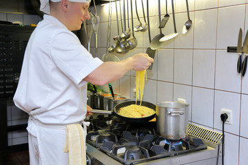 Gotowanie spaghetti na kuchni w retauracji.