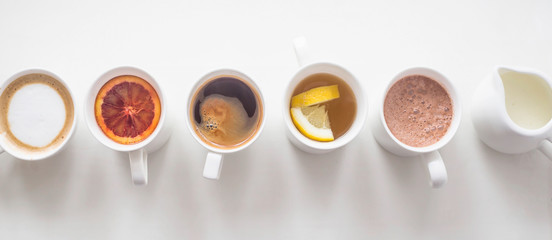 Several different hot drinks on the white table - coffee shop menu