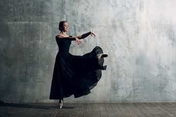 Ballerina female. Young beautiful woman ballet dancer, dressed in professional outfit, pointe shoes and black tutu.
