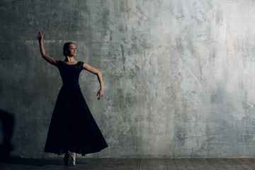 Ballerina female. Young beautiful woman ballet dancer, dressed in professional outfit, pointe shoes and black tutu.