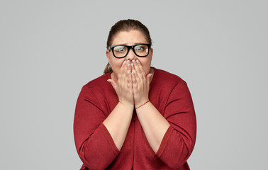 Shocked plump woman covering mouth