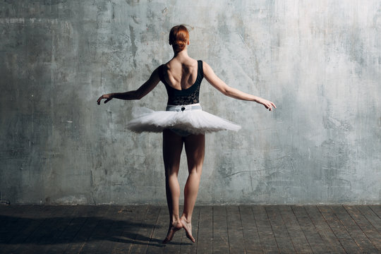 Ballerina female. Young beautiful woman ballet dancer, dressed in professional outfit, pointe shoes, black top and white tutu.
