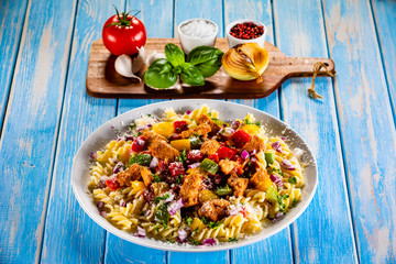 Pasta with vegetables on wooden background