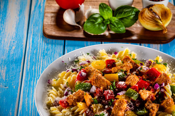 Pasta with vegetables on wooden background