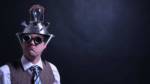 Nerd with aluminum hat looks into the camera