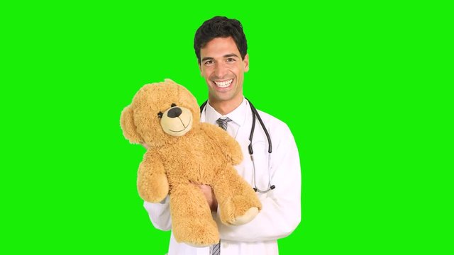 Doctor holding a teddy bear, pediatrician concept, chroma key