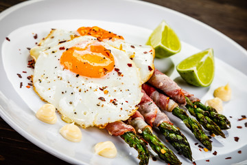 Fried egg with asparagus on white background
