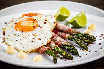 Fried egg with asparagus on white background