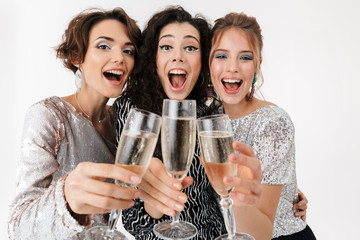 Young happy women friends posing isolated over white wall background. on a party.