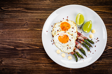 Fried egg with asparagus on white background