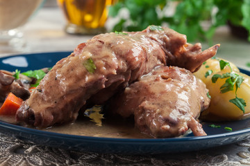 Stewed rabbit legs with vegetables