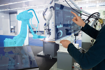 The engineer uses a futuristic projection touch screen to control robots in a smart factory. Smart industry 4.0 concept
