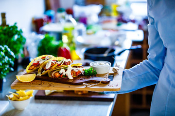 Waitress with tacos on cutting board