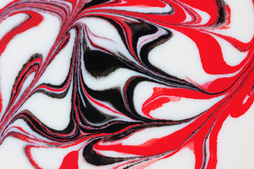 White, red and black paint blend together.