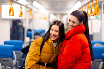 Young positive females in railway train.