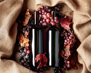 Red wine and grapes on a table covered with burlap.