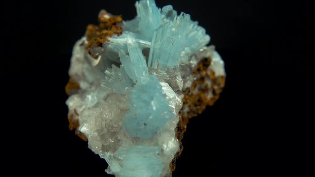 Seamlessly rotating a light blue mineral (Baryte) in front of black background