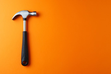 Metal hammer on an orange background