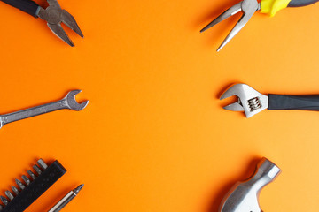 Hammer, pliers, screwdriver on an orange background - obrazy, fototapety, plakaty