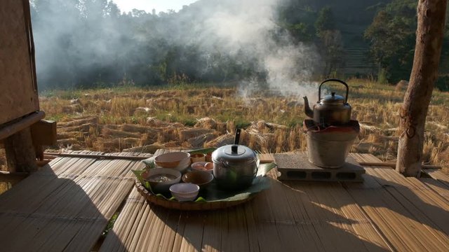 Lifestyle of Local Asian food In the rice field countryside Thailand.Blowing the fireplace for cooking in traditional kitchen in the morning. Hot chicken and rice soup, egg and herb tea