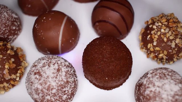 Bonbon chocolates closeup texture video on rolling rotating looping plate