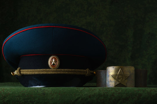 Leather army belt and Russian cap on a green background