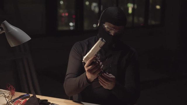 terrorist with a weapon on the background of the night city, charges the gun