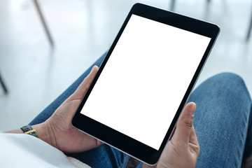 Mockup image of a woman holding black tablet pc with blank white screen while sitting in cafe
