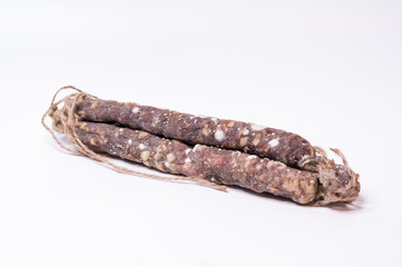 Three sticks of sausage with mold. Meat sausages in the center of the frame.