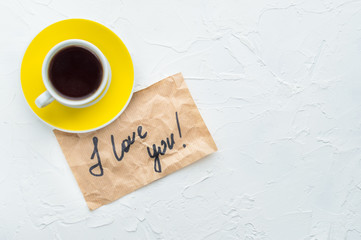 Yellow cup of coffee on a white background. Minimalism. Top view. I love you. Copy space