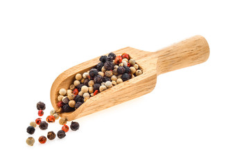 dried peppers in wood scoop isolated on white background
