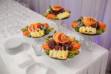 Candy bar decorated with fruit, green background.