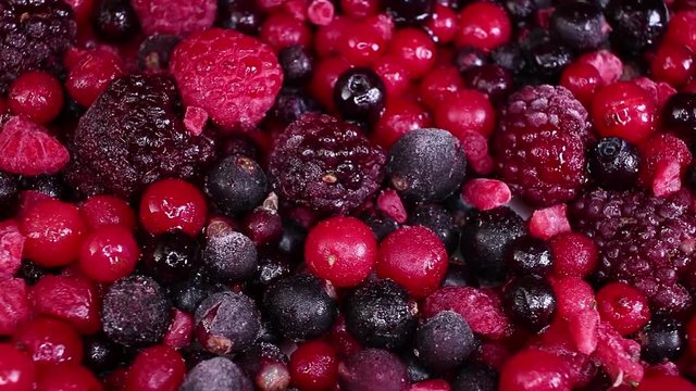 Berry fruit mix blueberry blackberry mulberry closeup texture video on rolling rotating looping plate