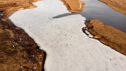 Aerial view of winter fishing.Dangerous fishing on the last ice.