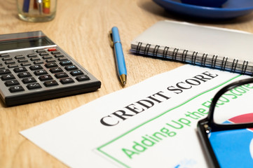 Credit score report with calculator on a table.