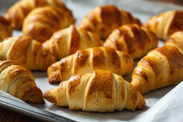 Homemade butter croissants on wooden background.