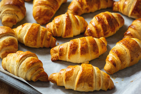 Homemade butter croissants on wooden background.