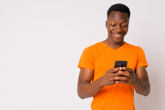 Portrait of young happy African man using phone