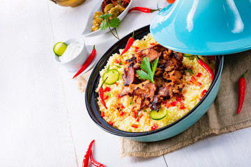 Tajin with couscous, vegetables and meat on white background