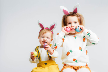 Happy easter. Funny children with rabbit ears celebrate Easter. Light gray background.