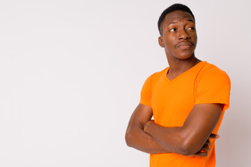 Portrait of young handsome African man thinking with arms crossed