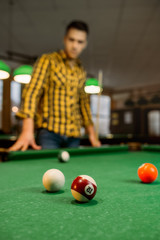 Male billiard player with cue, view from the table