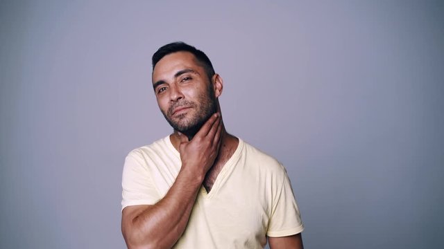 Smiling hispanic man looking at camera smiling touching his beard