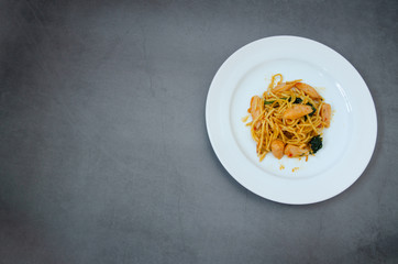 Spaghetti with sausage, Stir-fried sausage, Italian food.Spaghetti with red sauce, white plate on the table in the morning restaurant.