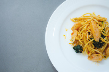 Spaghetti with sausage, Stir-fried sausage, Italian food.Spaghetti with red sauce, white plate on the table in the morning restaurant.